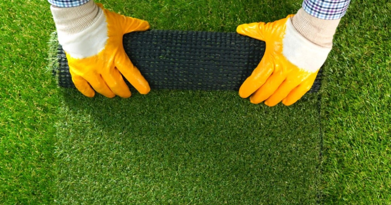 Professional artificial grass drainage installation process with expert hands